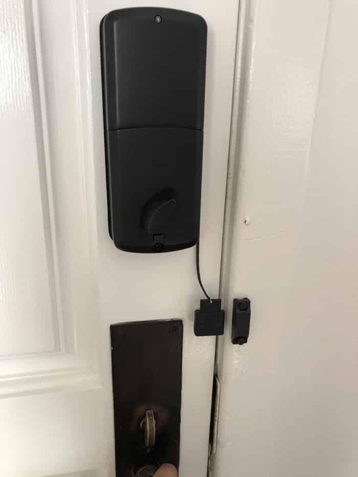 Igloohome keypad: Finished keypad, sensor and interior thumb-turn on a white six-panel door.