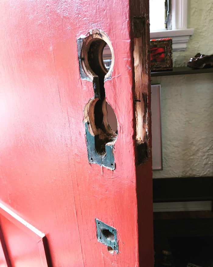 Old locks out, new set in: Old handle and deadbolt removed from a red front door.